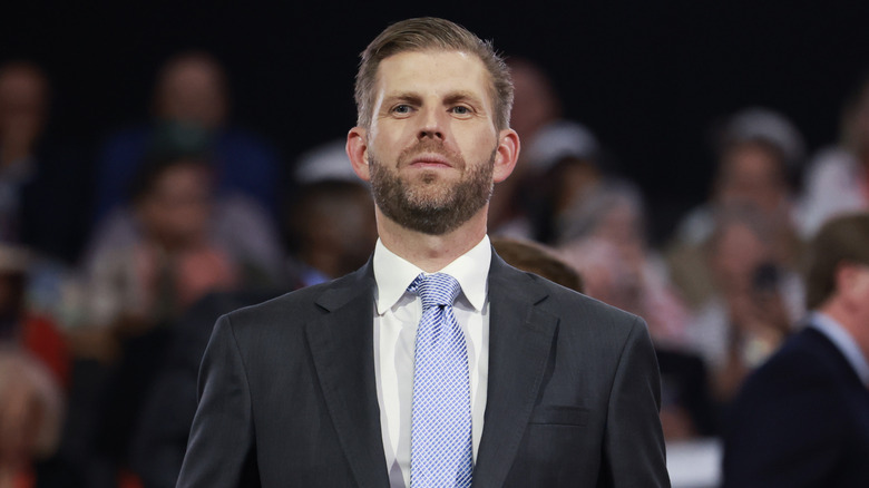 Eric Trump attending RNC 2024 in a dark suit with a purple tie