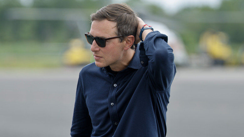 Jared Kushner walking with his hand behind his head and wearing sunglasses