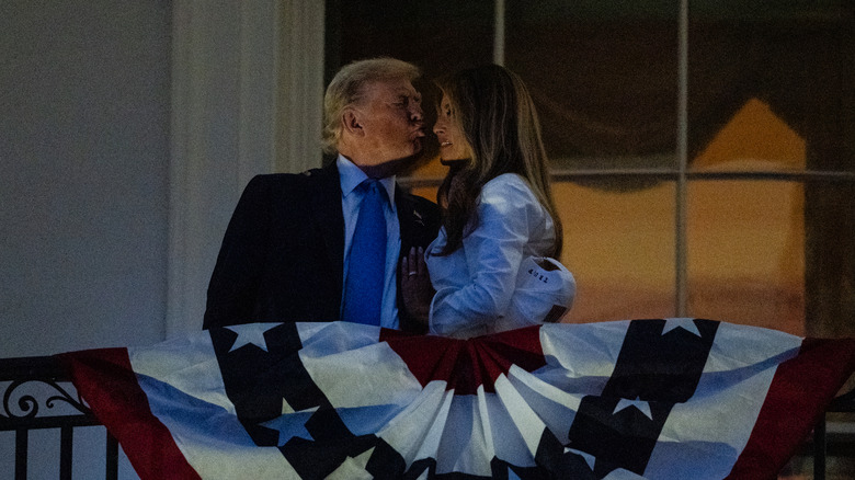 President Donald Trump and First Lady Melania Trump share a kiss as they watch fireworks during a Fourth of July celebration at the White House on July 4, 2025 in Washington, DC.