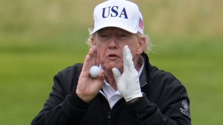 Donald Trump with golf ball holding hands apart