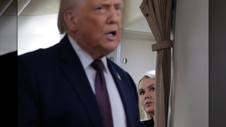 Karoline Leavitt watching Donald Trump speak to reporters on AIr Force One