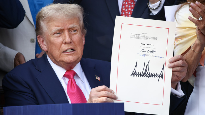 Donald Trump holding the Big Beautiful Bill
