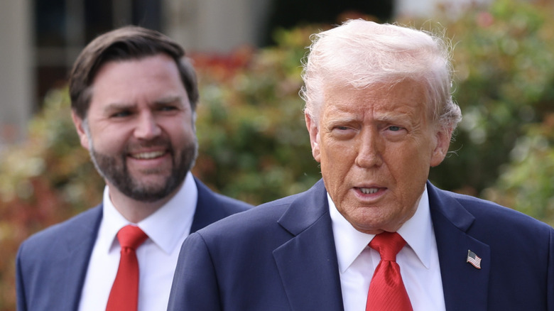 JD Vance smiling behind Donald Trump
