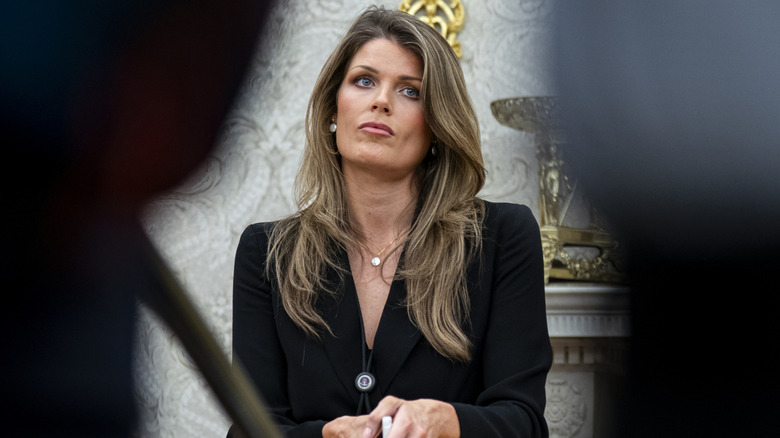 Lindsey Halligan flanked by the silhouettes of two people