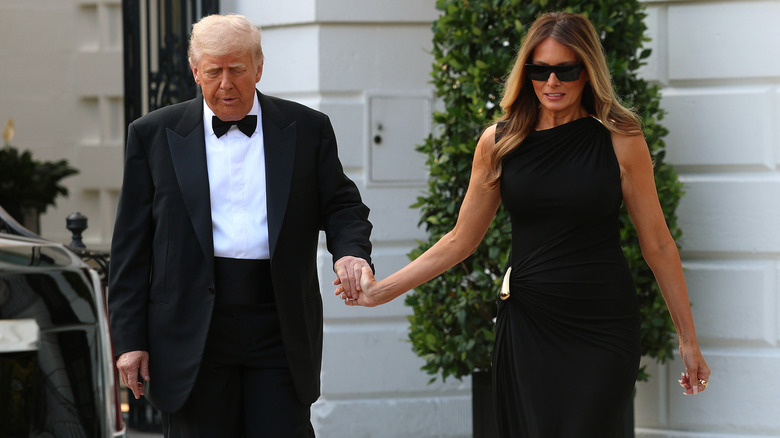 Donald and Melania Trump walking and sort of holding hands
