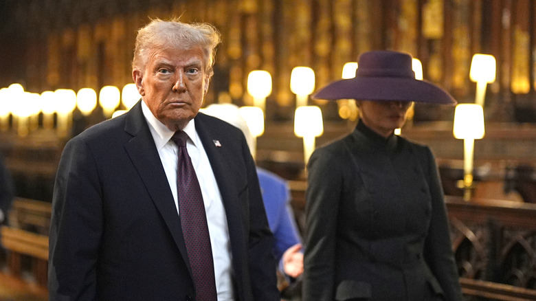 Donald Trump looks at the camera while Melania Trump looks down