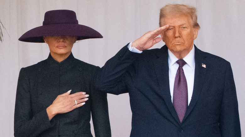 Melania Trump puts her hand over her heart while Donald Trump salutes