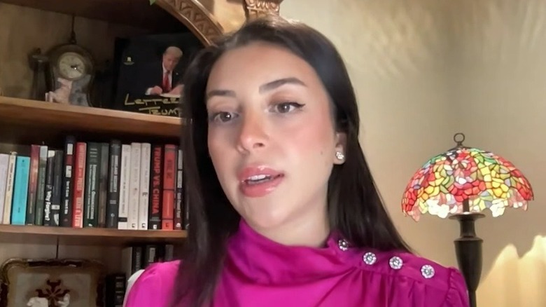 Julia Varvaro speaking in front of a bookcase and stained glass lamp.