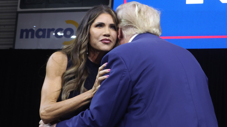 Noem looking thoughtful while she hugs Donald Trump