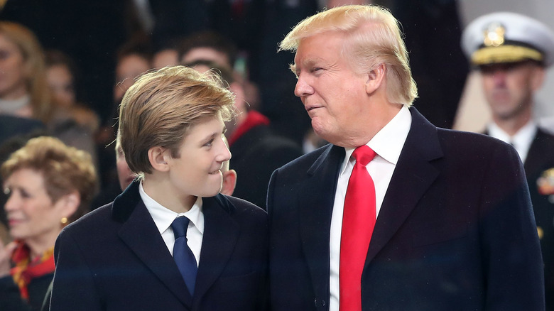 Barron Trump and Donald Trump turned towards each other