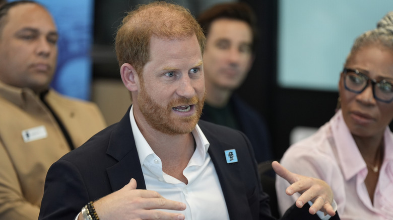 Prince Harry talking to a crowd during return trip to UK