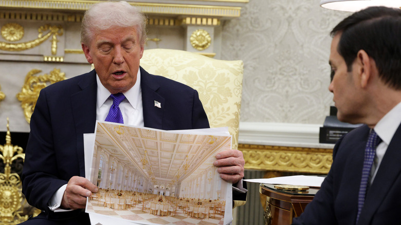 Donald Trump in the Oval Office showing a sketch of his new ballroom