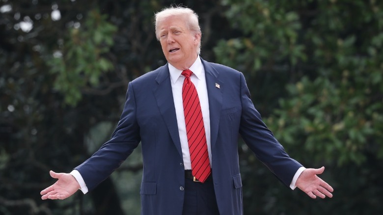 Donald Trump gestures while on the roof of the West Wing of the White House (2025)