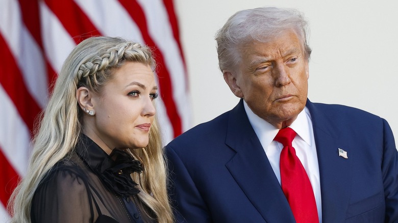 Erika Kirk and Donald Trump hold the Medal of Freedom on stage