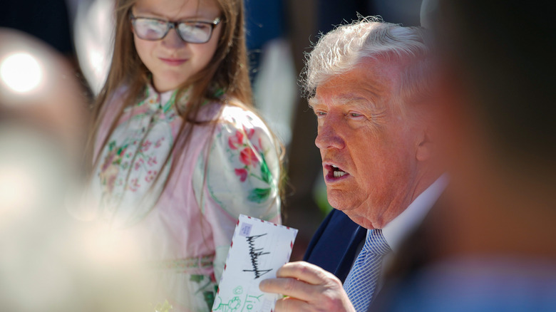 Donald Trump holding up signed envelope 2026 Easter Egg Roll