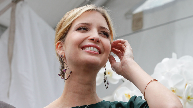 Closeup of Ivanka Trump smiling as she tucks her hair behind her ear