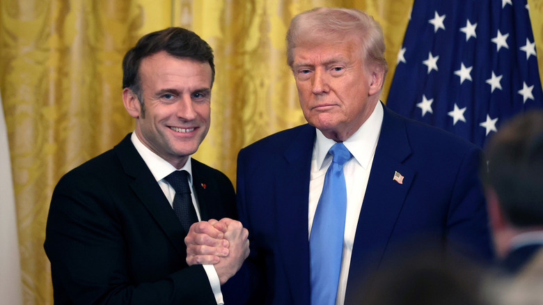 Donald Trump and Emmanuel Macron posing together while gripping each other's hands