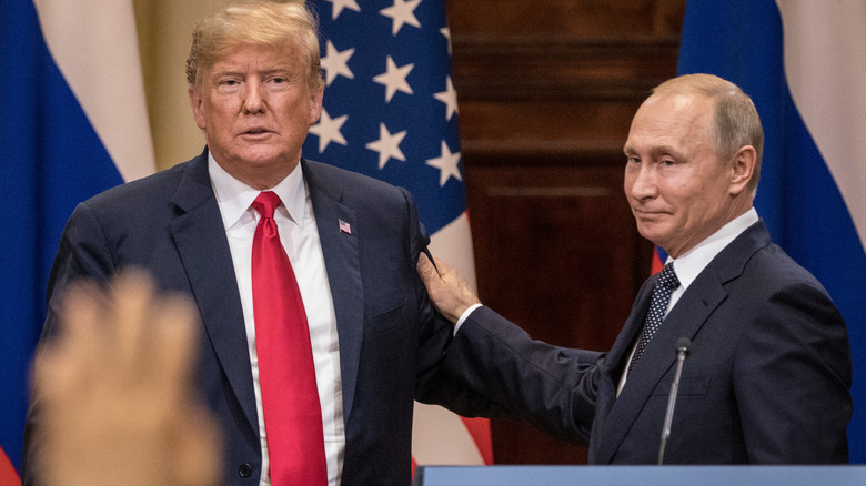 Donald Trump and Vladimir Putin casually holding onto each other during an event