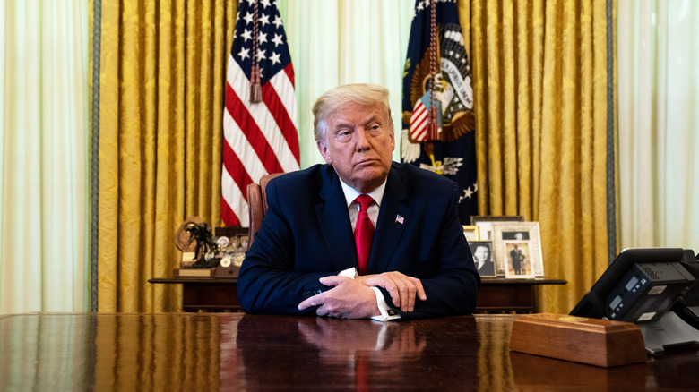 Donald Trump seated behind the Resolute Desk