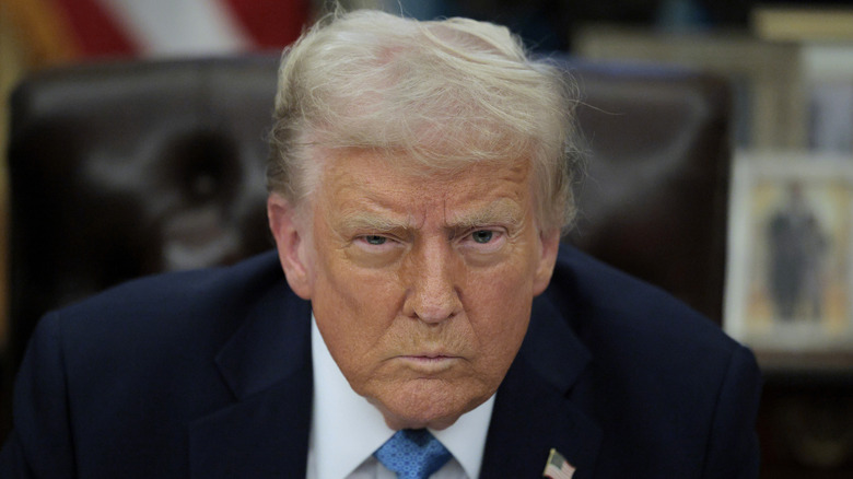 Donald Trump leans forward and frowns