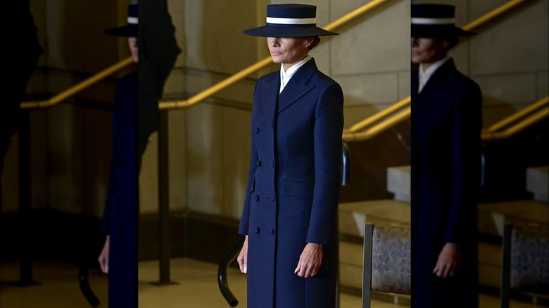 Melania Trump wearing a hat and long navy coat at the 2025 Presidential Inauguration