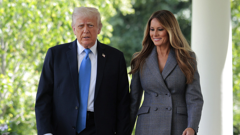 Donald Trump and Melania Trump walking together outside the White House
