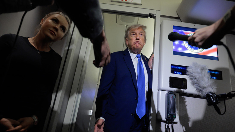 Donald Trump talking to reporters on Air Force One with Karoline Leavitt next to him