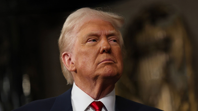 President Donald Trump posing at the U.S. capitol in a suit and red tie.