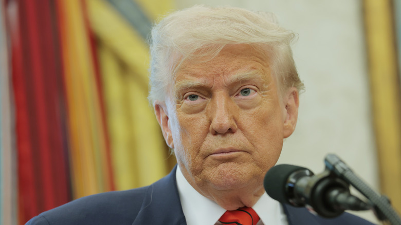 Donald Trump stands in front of a microphone