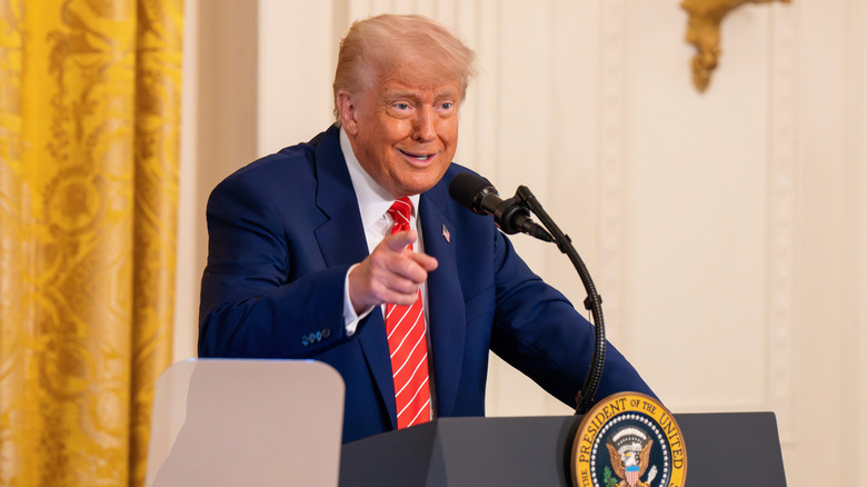 Donald Trump pointing while standing at a podium at the White House