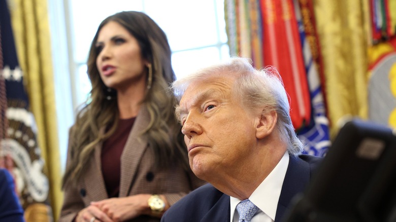 Close-up of Donald Trump (R) in the Oval Office with Kristi Noem (L) blurred in the background