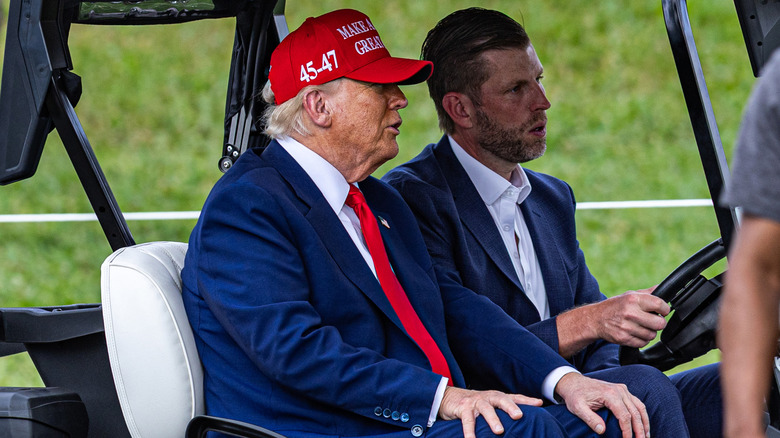 Donald Trump and Eric Trump riding in a golf cart together