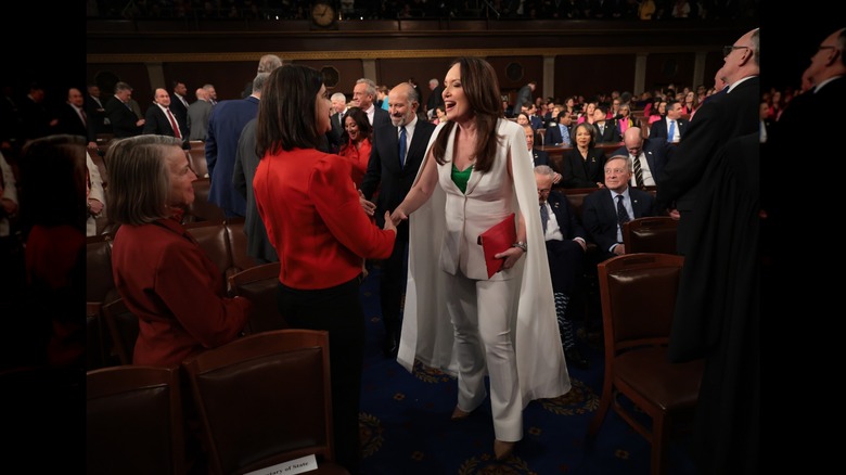 Brooke Rollins shaking hands with a woman in red on the Congress floor.