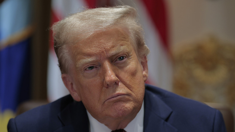 Donald Trump attending a cabinet meeting in a blue blazer, white collar shirt and blue tie.