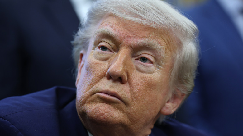 Donald Trump close-up showing a serious face and defined lighter skin area around his eyes