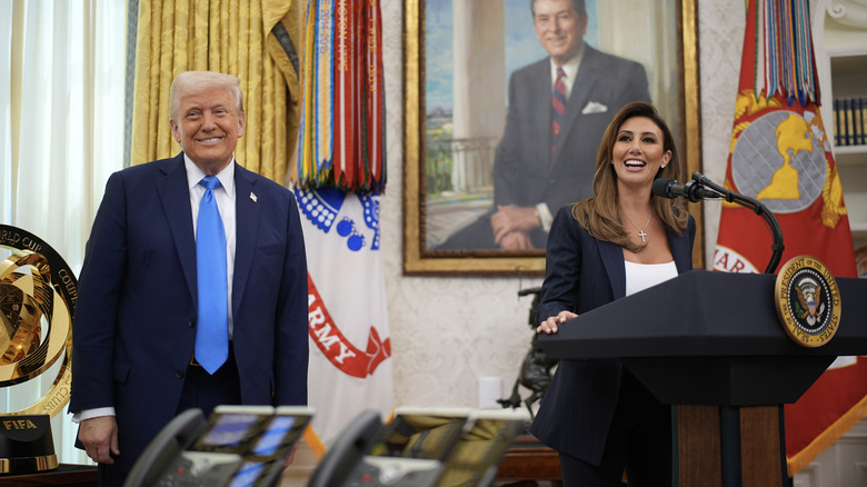 Alina Habba and Donald Trump smiling in the Oval Office during a press conference