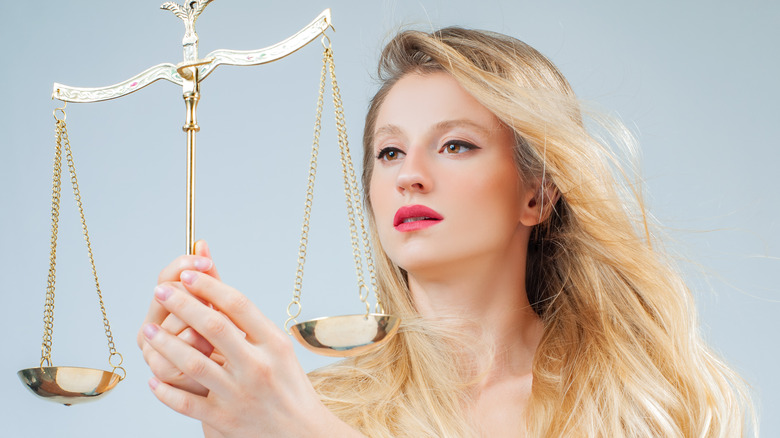 Woman holding Libra scales