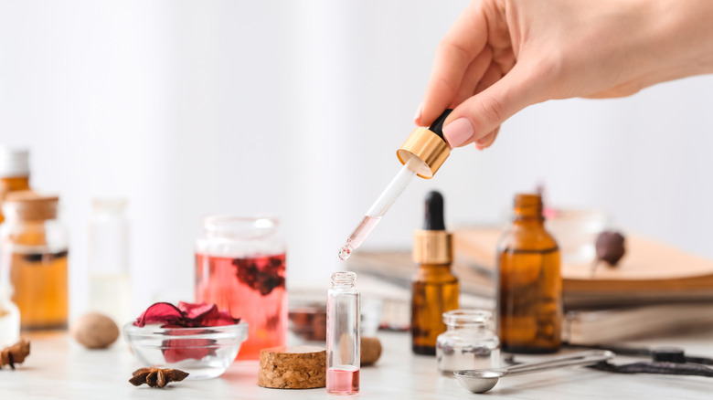 Hand using a dropper for aromatherapy