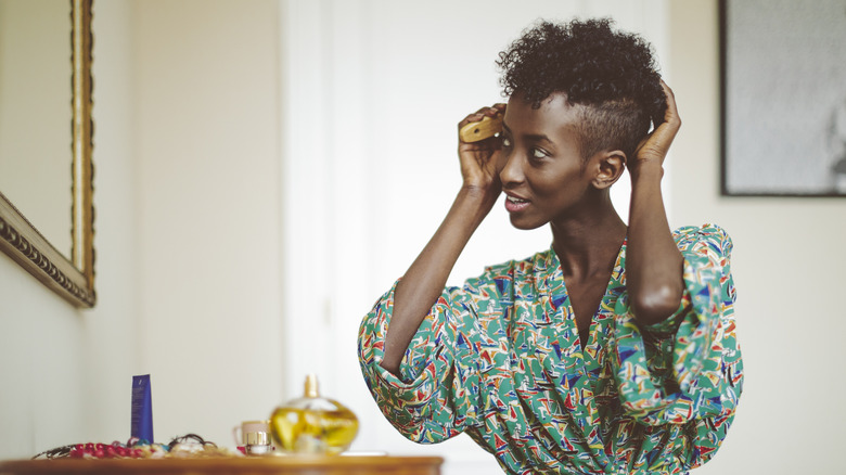 Woman styling hair in mirror