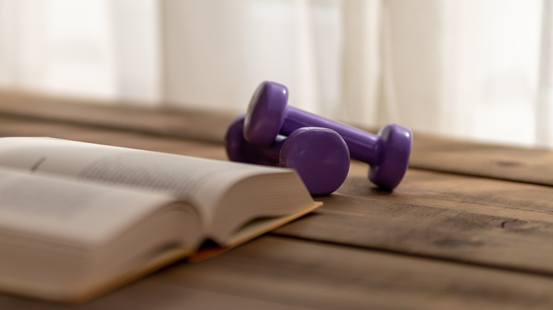 Dumbbells next to a book