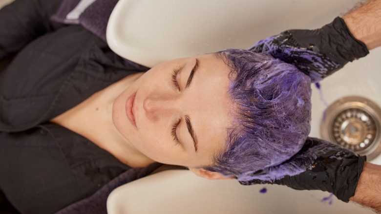 stylist applying purple shampoo