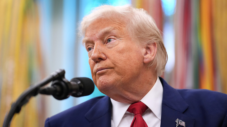 Donald Trump standing next to microphone looking into the distance