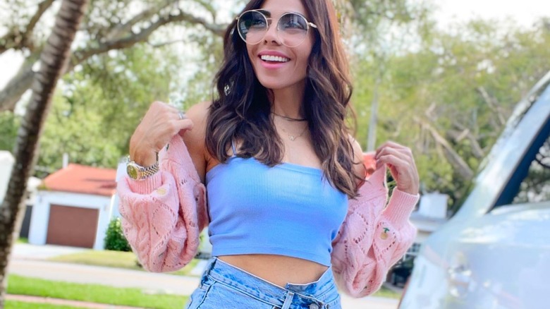 woman wearing pink shrug and jeans