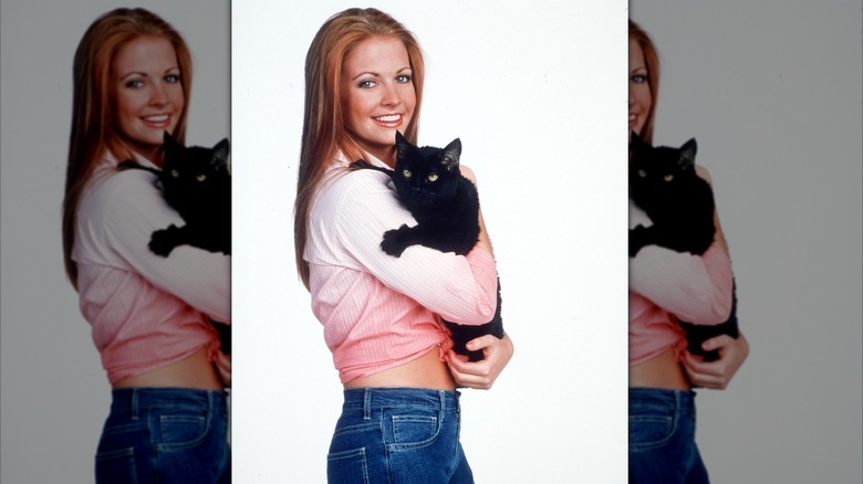 Melissa Joan Hart holding a black cat in a promo for Sabrina the Teenage Witch
