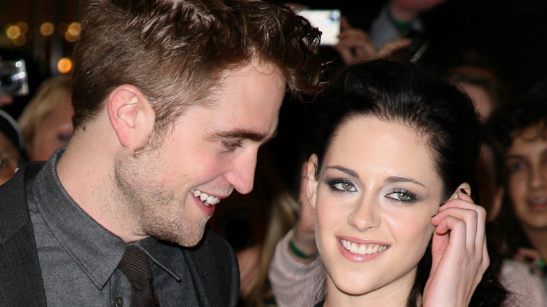 Robert Pattinson looking at Kristen Stewart on red carpet 