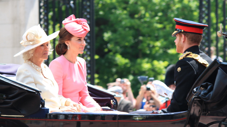 Queen Camilla, Kate Middleton, and Prince Harry riding in a carriage for Trooping the Colour