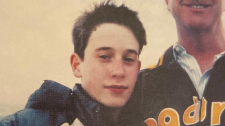 A teenage Tyler Henry smiling next to his father