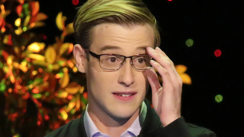 Closeup of Tyler Henry adjusting his glasses