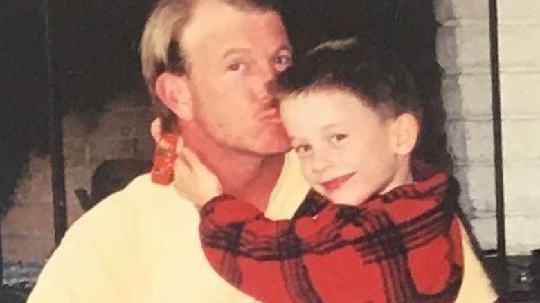 Tyler Henry as a child hugging his father as he kisses his son on the head