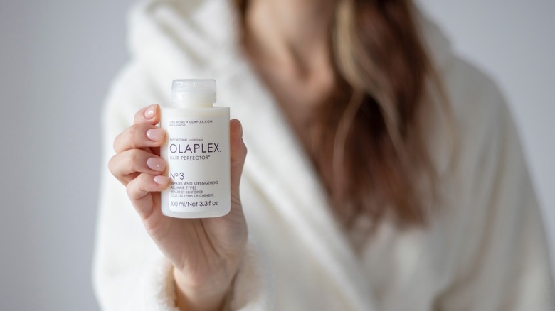 Woman holding bottle of Olaplex No.3